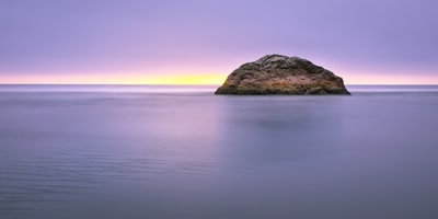 风景摄影的棕色岩层中间的海洋
